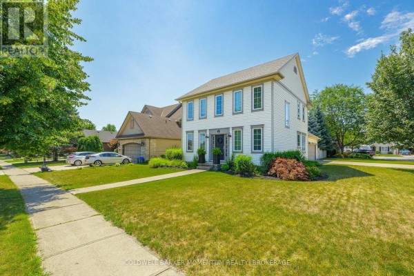 Side exterior view of a two-story white house with grey trim, garage, and sidewalk. - 15 Virginia Street, Welland