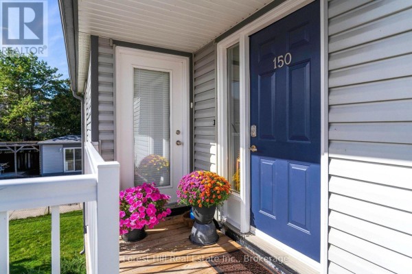 Close-up of the townhouse entrance door, number 150, with decorative potted flowers. - 150 - 53 Trott Boulevard, Collingwood