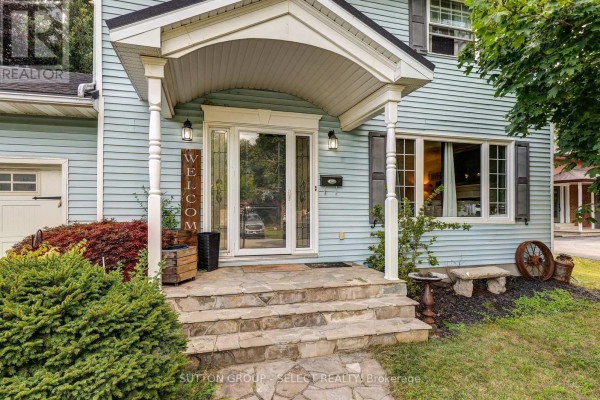 Close-up of the covered front entryway with stone steps and a white front door. - 150 Dufferin Street, Aylmer