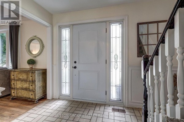Interior foyer with a white front door, tiled floor, and a chest of drawers. - 150 Dufferin Street, Aylmer