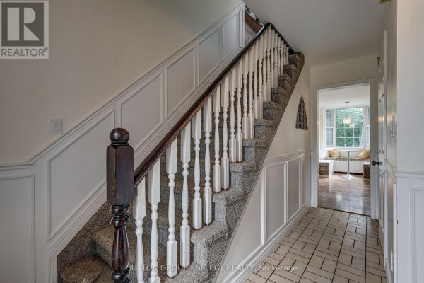 View of the carpeted staircase with white spindles and a dark wood handrail. - 150 Dufferin Street, Aylmer