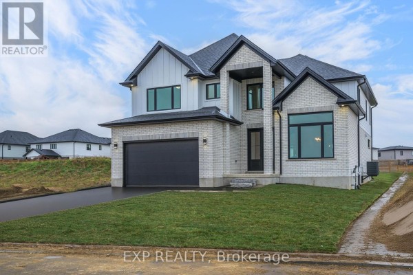 Side view of the house showing large windows and a landscaped yard. - 150 Locky Lane, Middlesex Centre