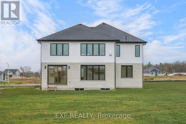 Back view of the home featuring multiple windows and a grassy area. - 150 Locky Lane, Middlesex Centre