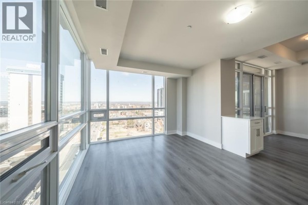 Corner view of living room with white cabinets and large windows showing city skyline. - 150 Main Street W Unit# Ph3, Hamilton