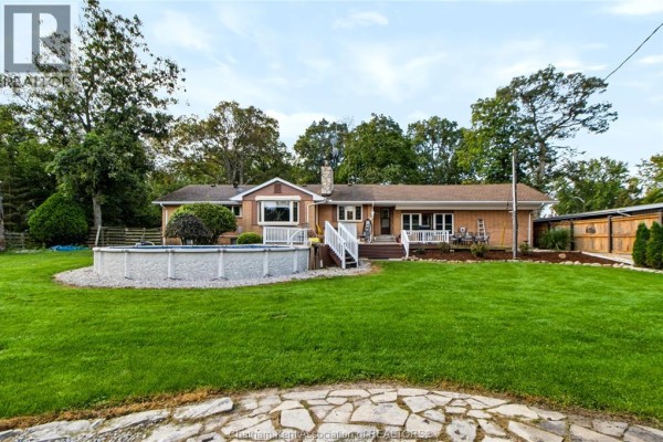 Rear exterior view of the house with an above-ground pool and a large grassy backyard. - 150 Murdoch Street, Harrow