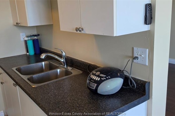 Kitchen counter with a double sink, chrome faucet, and a portable stereo system. - 150 Park West Unit# 1112, Windsor