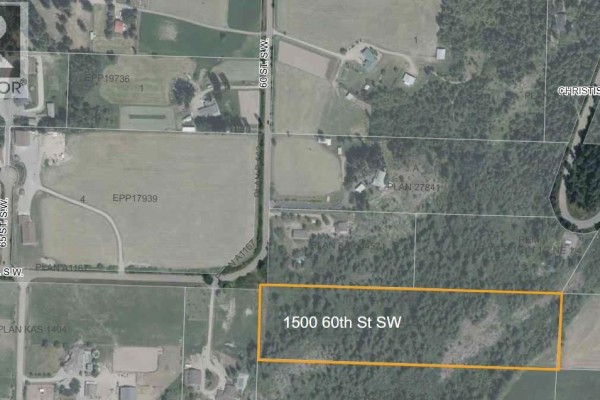 Overhead view of a wooded hillside property with scattered houses and farmland in the distance. - 1500 60 Street Sw, Salmon Arm
