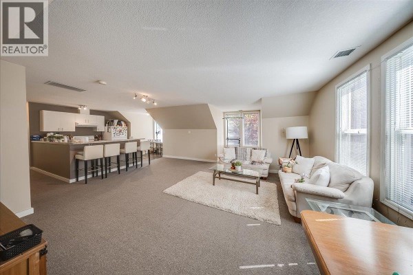 Living area with sofas, coffee table, and a kitchen counter with stools. - 1500 Cedar Avenue, Trail
