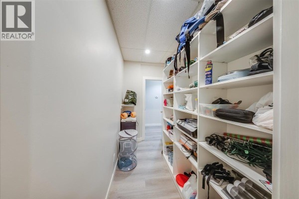Hallway with extensive shelving units filled with various items. - 1500 Cedar Avenue, Trail