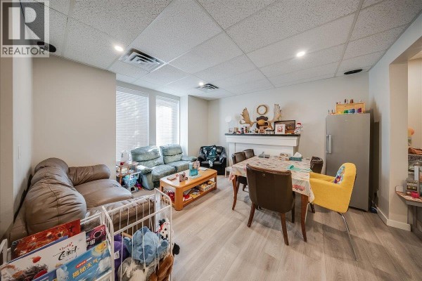 Living and dining area with sofas, chairs, table, and refrigerator. - 1500 Cedar Avenue, Trail