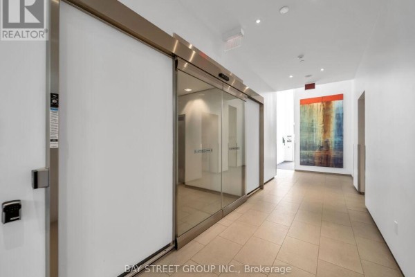 A long, wide hallway with beige tile floors and large glass windows. - 1501 - 105 The Queensway Avenue, Toronto