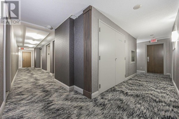Open-concept kitchen with stainless steel appliances and a living area. - 1501 - 21 Hillcrest Avenue, Toronto