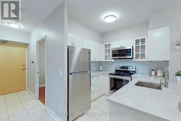 Compact kitchen with white cabinetry, stainless steel appliances, and subway tile backsplash. - 1501 - 4978 Yonge Street, Toronto