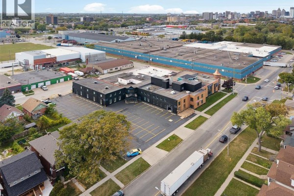 Aerial view showing the commercial building and nearby industrial structures. - 1501 Howard Avenue Unit# 201c, Windsor