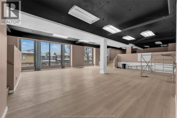 Spacious interior room with large windows, light-colored flooring, and black ceiling. - 1501 Howard Avenue Unit# 201c, Windsor