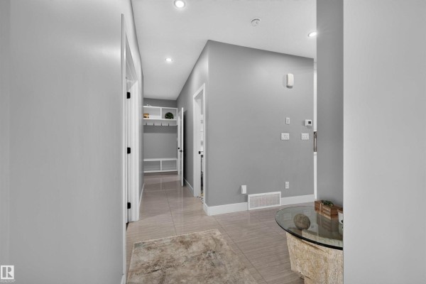 Hallway with tile flooring, grey walls, and white doors leading to rooms. - 15011 10 St Nw, Edmonton