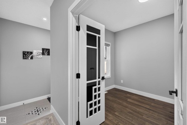 Interior view of a room with grey walls, a window, and wood flooring. - 15011 10 St Nw, Edmonton