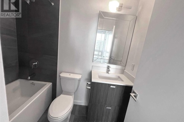 Bathroom with a bathtub, toilet, vanity, and mirrored medicine cabinet. - 1502 - 56 Forest Manor Road, Toronto