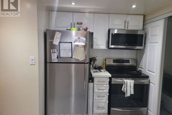 Small kitchen with stainless steel refrigerator and microwave. - 1502 - 88 Corporate Drive, Toronto