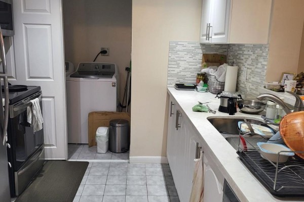 Kitchen with white cabinets, countertops, and stainless steel sink. - 1502 - 88 Corporate Drive, Toronto