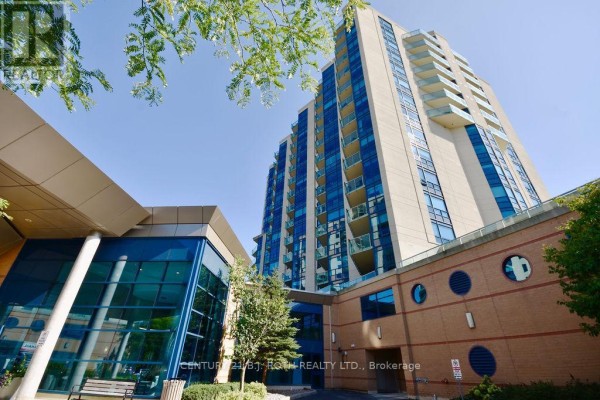 Low-angle view of a modern glass and brick apartment building on a sunny day. - 1505 - 37 Ellen Street, Barrie