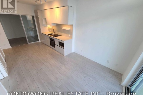 Open concept living area with a modern kitchen and large windows overlooking the city. - 1505 - 950 Portage Parkway, Vaughan
