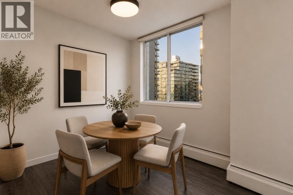 Living room with grey sofa, coffee table, artwork, and balcony access with city view. - 1505 1251 Cardero Street, Vancouver