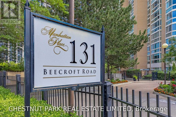 Sign for Manhattan Place at 131 Beecroft Road, Toronto, with a black metal fence in the foreground. - 1506 - 131 Beecroft Road, Toronto