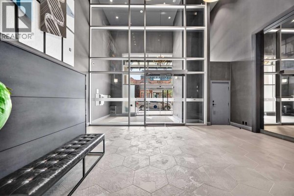 Interior lobby of The Guardian building with dark walls, a leather bench, and hexagonal floor tiles. - 1507, 1188 3 Street Se, Calgary