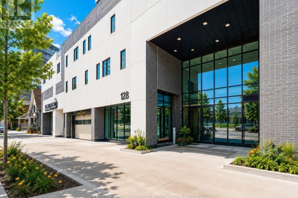 Bright lobby with white reception desk, marble tile floors, modern light fixtures, and elevator doors. - 1507 - 128 King Street, Waterloo