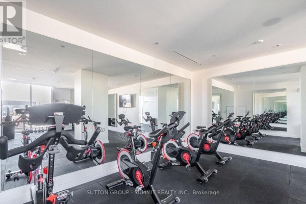 Fitness center with multiple spin bikes, mirrors, and rubber flooring. - 1507 - 135 East Liberty Street, Toronto