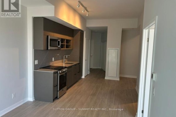 Kitchenette with grey cabinets, stainless steel appliances, and light wood flooring. - 1507 - 135 East Liberty Street, Toronto