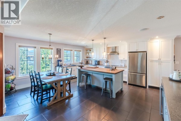 Open concept kitchen and dining area with island and stainless steel appliances. - 1507 Wharf Street, Summerland