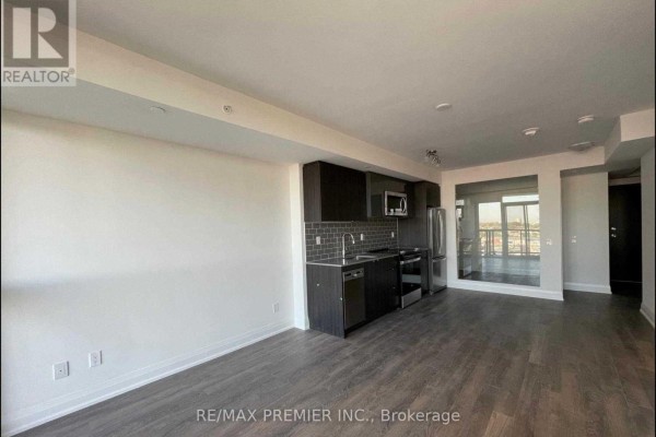 Open concept living area and kitchen with dark laminate flooring and floor-to-ceiling windows. - 1508 - 1461 Lawrence Avenue W, Toronto