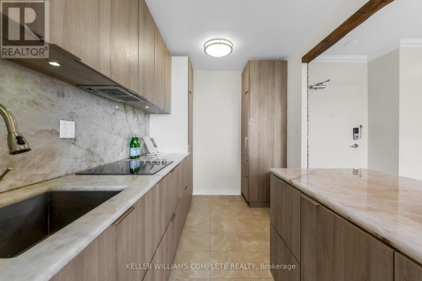 Modern kitchen with wood cabinets, marble backsplash, stainless steel sink, and induction cooktop. - 1508 - 1964 Main Street W, Hamilton