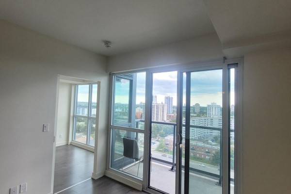 Corner of an empty room with large windows and a sliding glass door to a balcony with city views. - 1508 - 2 Sonic Way, Toronto
