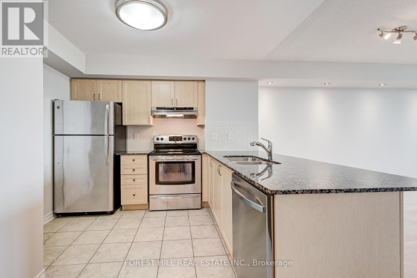 Open-concept kitchen with light wood cabinets, granite countertops, stainless steel appliances, and an island. - 1509 - 15 North Park Road, Vaughan