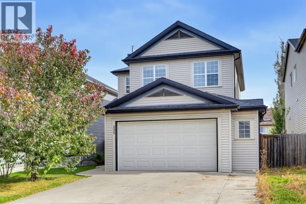 Front exterior of a light beige two-story house with a white double garage door. - 151 Copperfield Common Se, Calgary