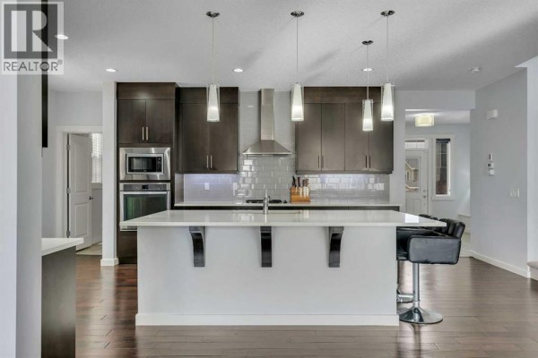 Bathroom with a bathtub, dual sinks, and modern tile accents. - 151 Stonemere Green, Chestermere