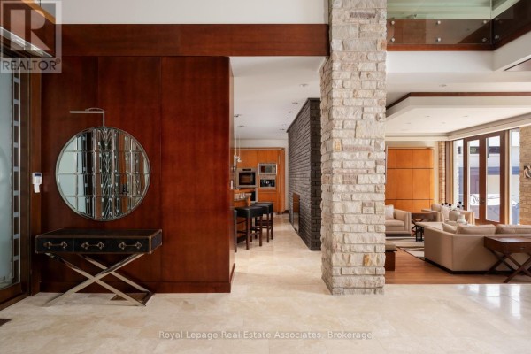 Interior view of the foyer, featuring a stone pillar, wood accents, and a glimpse into the living area. - 1510 Pinetree Crescent, Mississauga