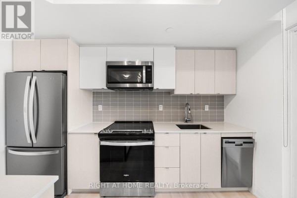 Close-up of the modern kitchen with stainless steel appliances and light wood cabinets. - 1511 - 1461 Lawrence Avenue, Toronto