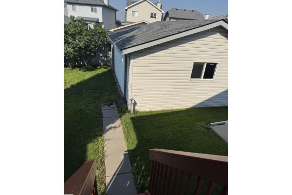 View from above the entryway showing a white door, white walls, and a staircase railing. - 15112 139 St Nw, Edmonton