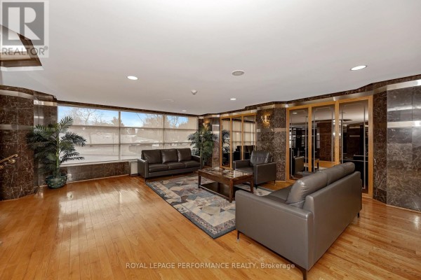 Entrance area with a covered drop-off and landscaped surroundings. - 1512 - 2760 Carousel Crescent, Ottawa