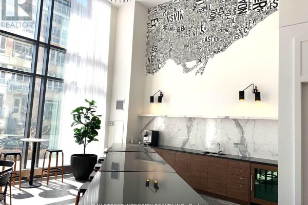Amenity space with marble countertops, a coffee maker, and a large map mural on the wall. - 1512 - 38 Iannuzzi Street, Toronto