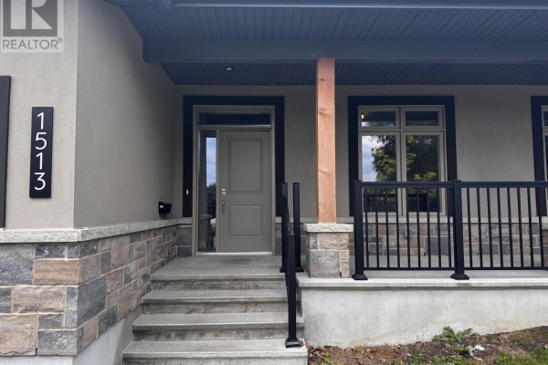 Close-up of the front entrance with a gray door, stone steps, and porch. - 1513 Flanders Road, Brockville
