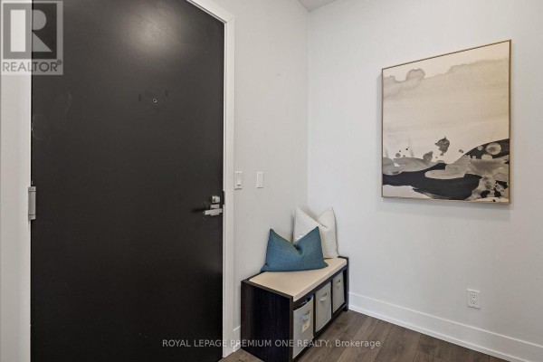 Apartment entrance with a dark door, bench seating, and abstract art on the wall. - #1514 - 9471 Yonge Street, Richmond Hill