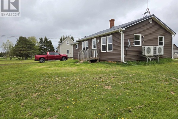 Side view of a brown, single-story house with a metal roof and attached AC units. - 15150 Rte 14, Nail Pond