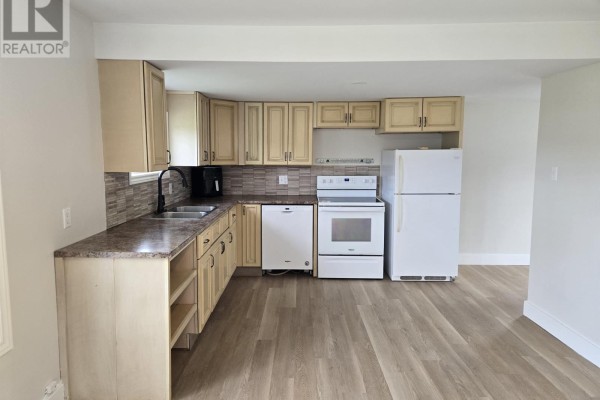 Kitchen with light wood cabinets, granite countertops, white appliances, and wood-look flooring. - 15150 Rte 14, Nail Pond