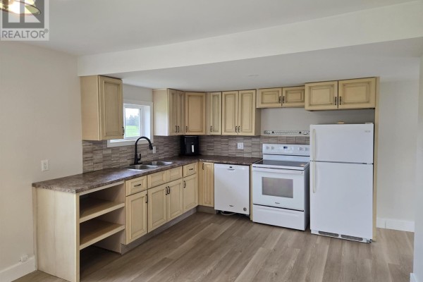 Corner view of a kitchen featuring light wood cabinets, granite countertops, and white appliances. - 15150 Rte 14, Nail Pond