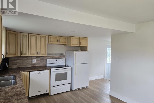 Kitchen with light wood cabinets, white appliances, granite countertops, and a doorway to another room. - 15150 Rte 14, Nail Pond